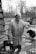 man in gray button up jacket standing beside black short coated dog