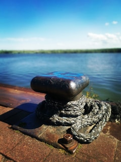 Close-up of a technician performing a load test on a heavy-duty marine bollard at a busy port.