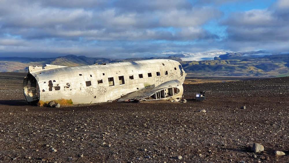 white airplane on gray sand during daytime