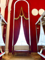 A deep crimson wall with framed charts and trading notes, creating a cozy yet professional atmosphere.