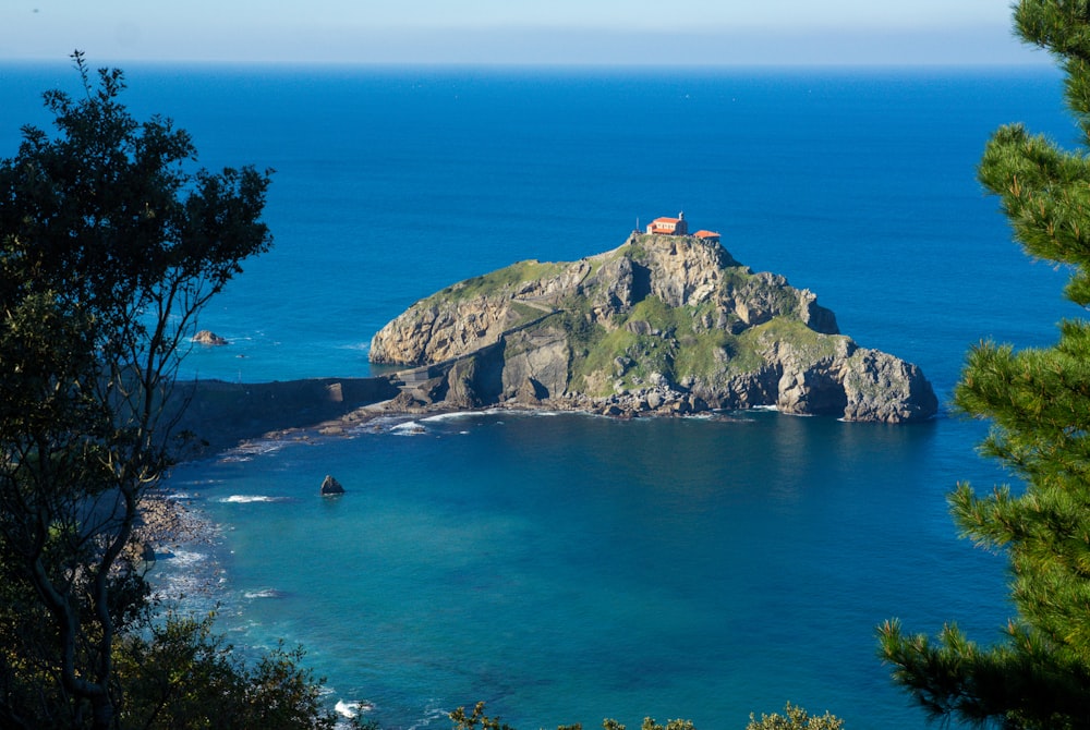 Montaña verde y marrón junto al mar azul durante el día