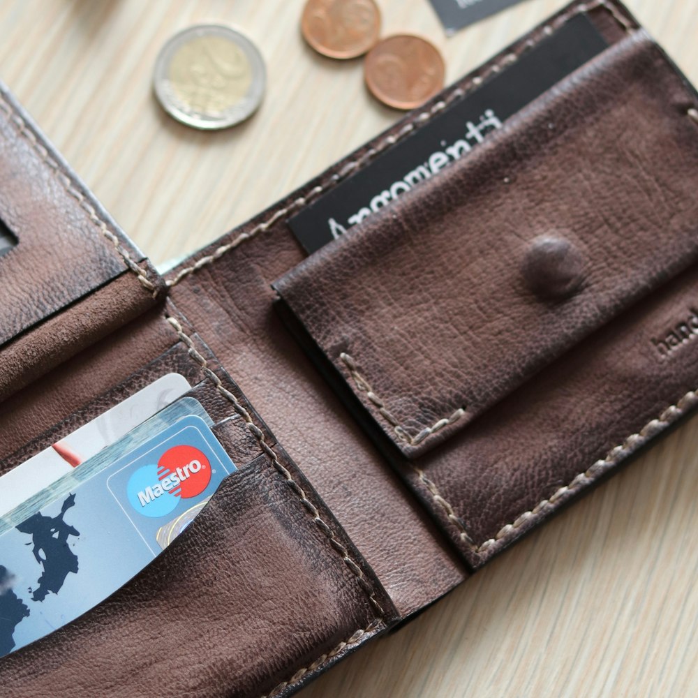 brown leather bifold wallet with coins and coins