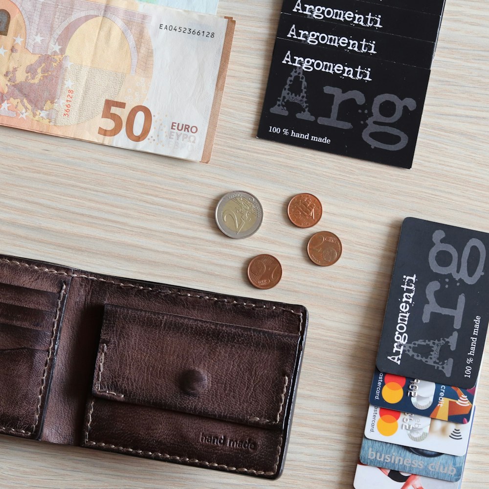 50 euro and coins on white wooden table