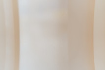 A softly textured surface with a smooth gradient of light beige tones, creating an abstract and minimalistic appearance.
