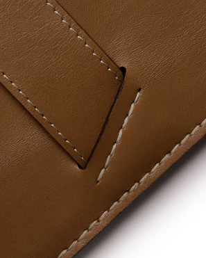 Close-up of a supple brown leather jacket highlighting fine stitching and texture.