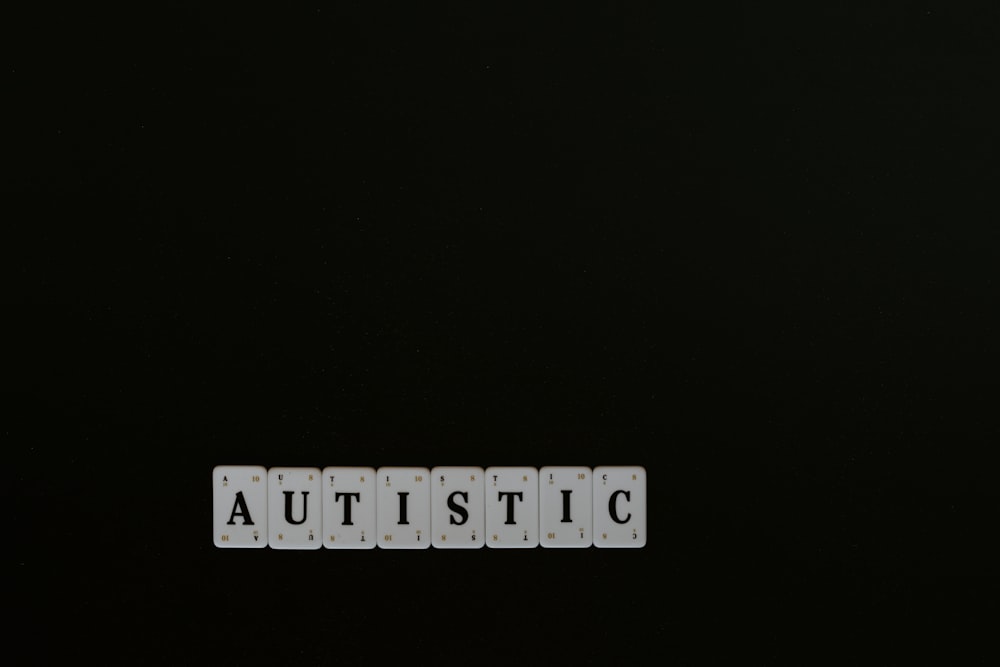 Das Wort autistisch mit weißen Buchstaben auf schwarzem Hintergrund geschrieben