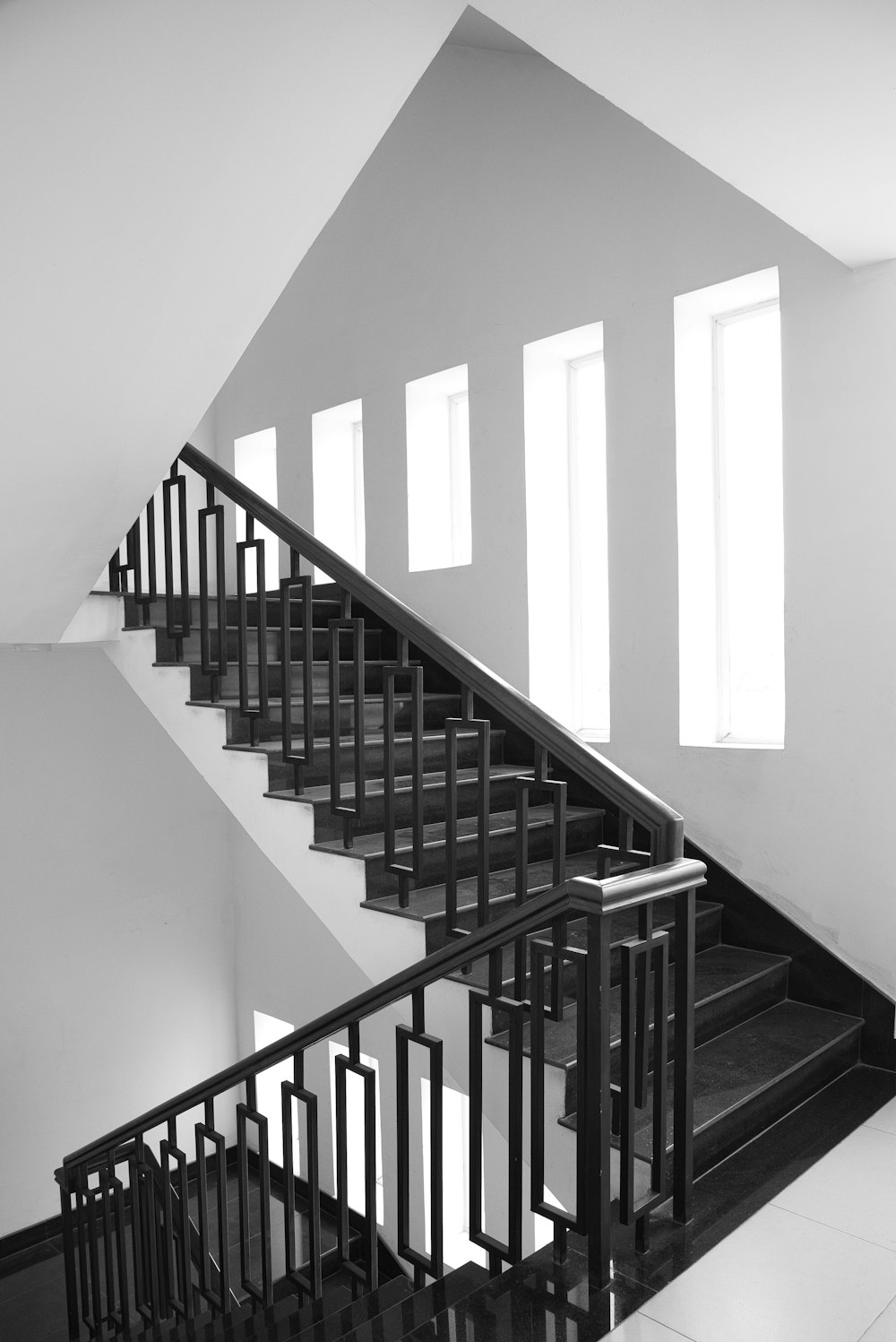 黒い金属の手すりが付いている白いコンクリートの階段