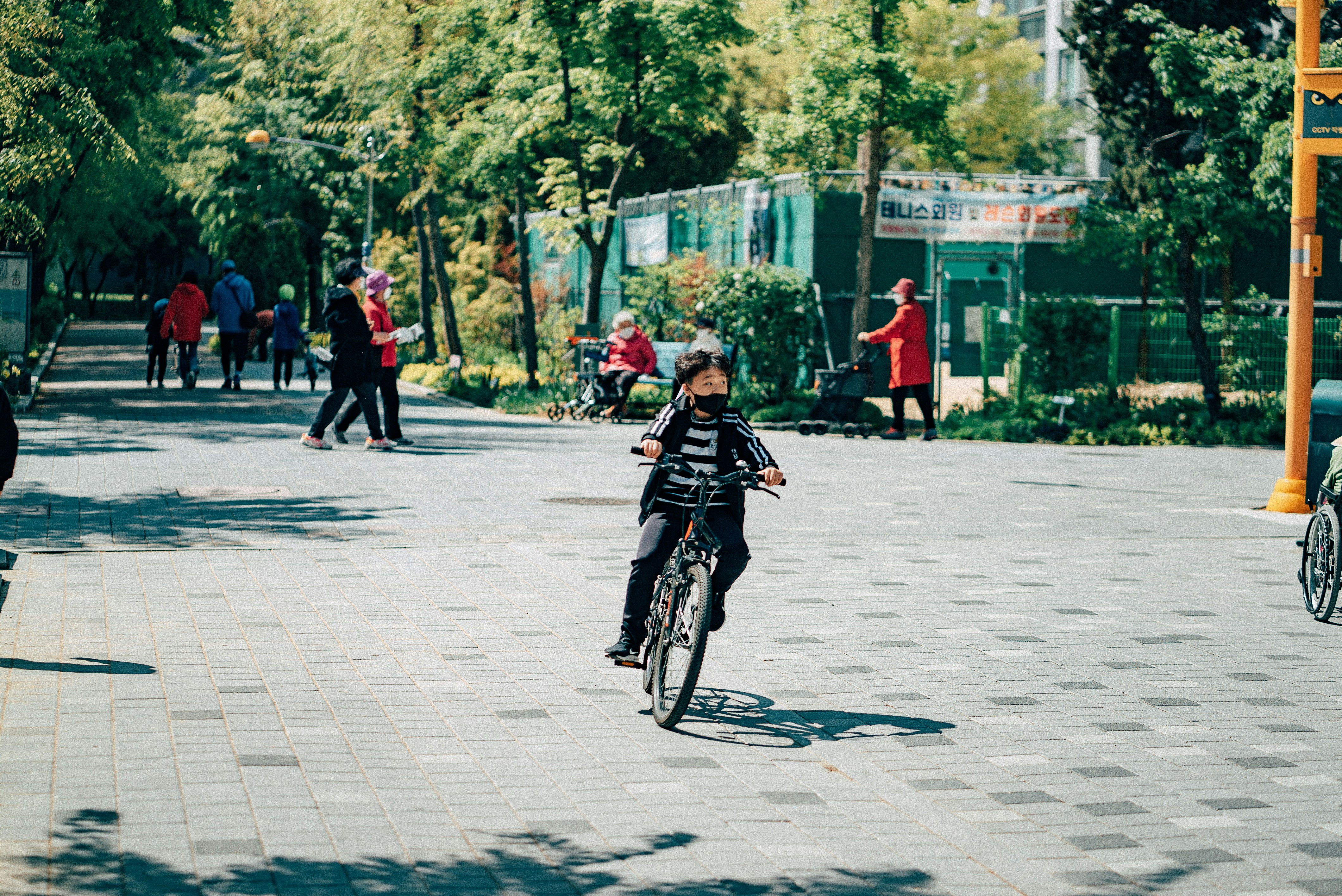 man in black jacket riding bicycle on road during daytime