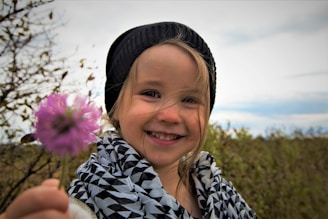 girl in black and white floral shirt smiling