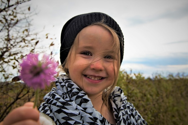 girl in black and white floral shirt smiling