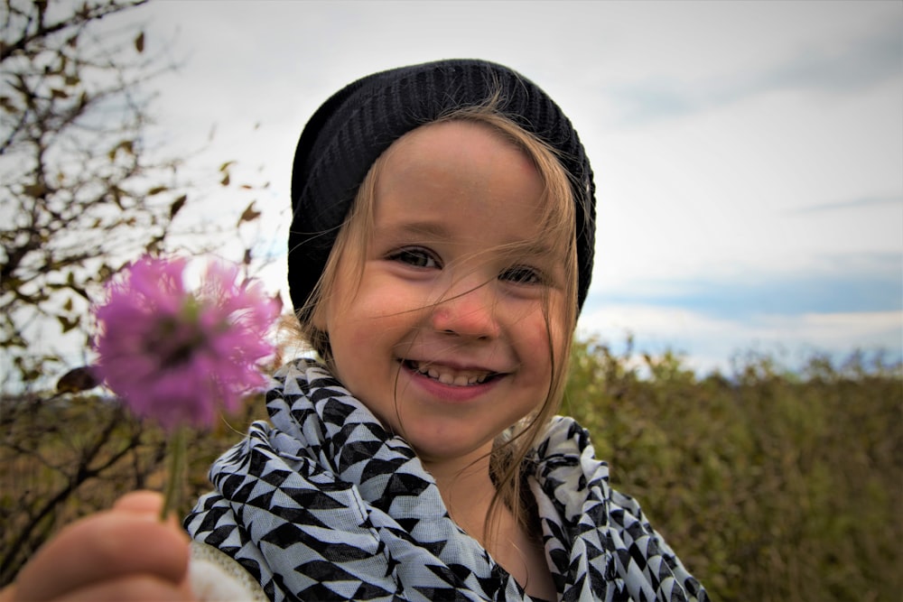 fille en chemise à fleurs noire et blanche souriant