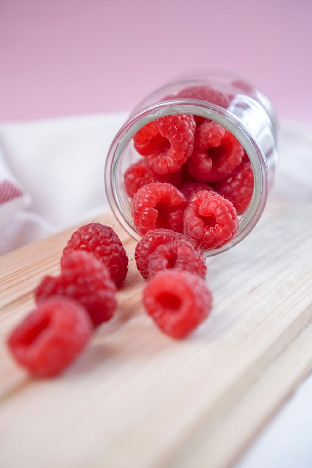 framboise rouge sur pot en verre transparent