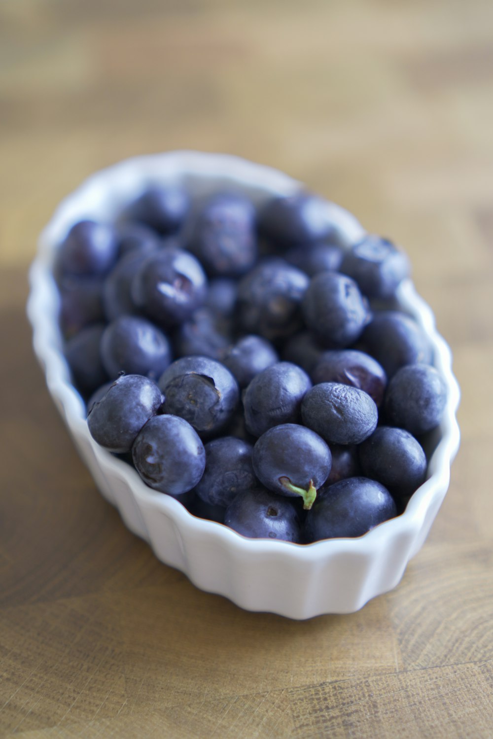 blue berries in white ceramic bowl