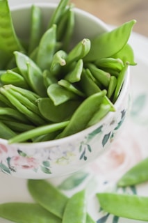 green beans on white and pink floral ceramic bowl