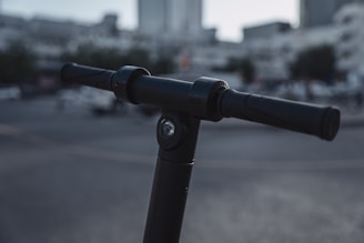 Close-up of a rider’s hand gripping the handlebar of a modern electric scooter.