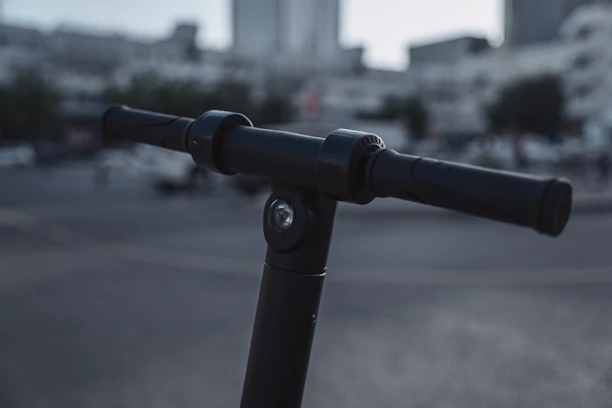 Close-up of a rider's hand gripping the futuristic handlebar of an Oxev scooter.