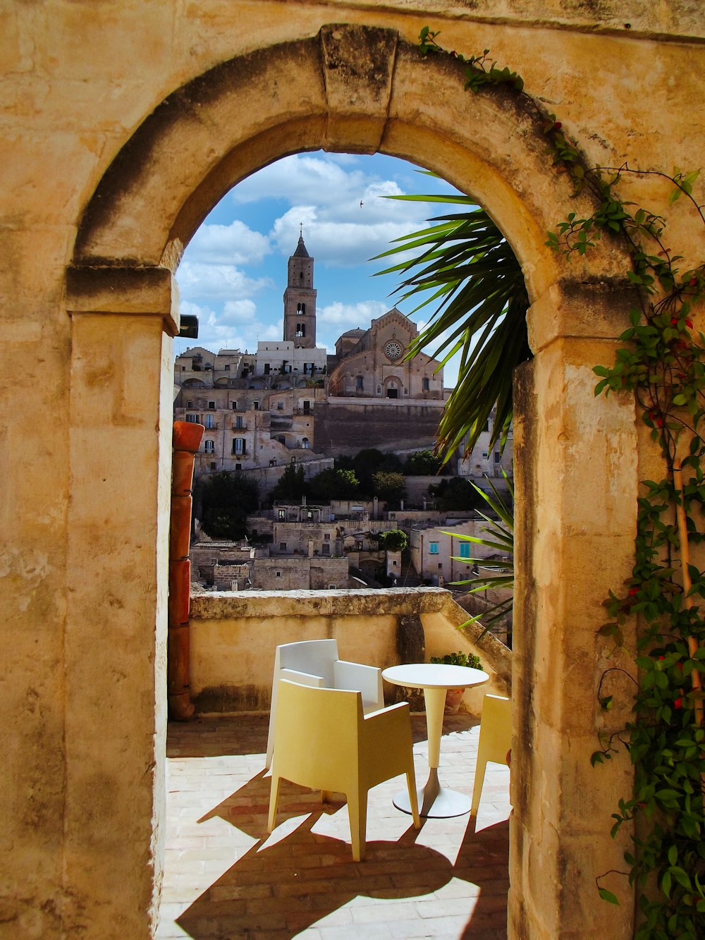 white plastic chairs and table near brown concrete building during daytime