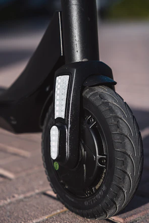 Close-up of a sleek electric scooter wheel on a modern urban pavement.
