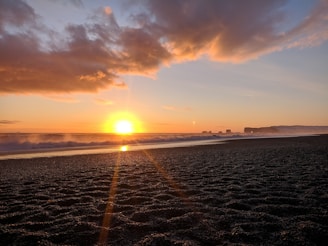 A breathtaking sunset over a serene beach with gentle waves, capturing the essence of wanderlust.