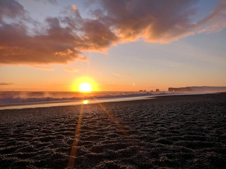 A breathtaking sunset over a tropical beach with golden sands and gentle waves.