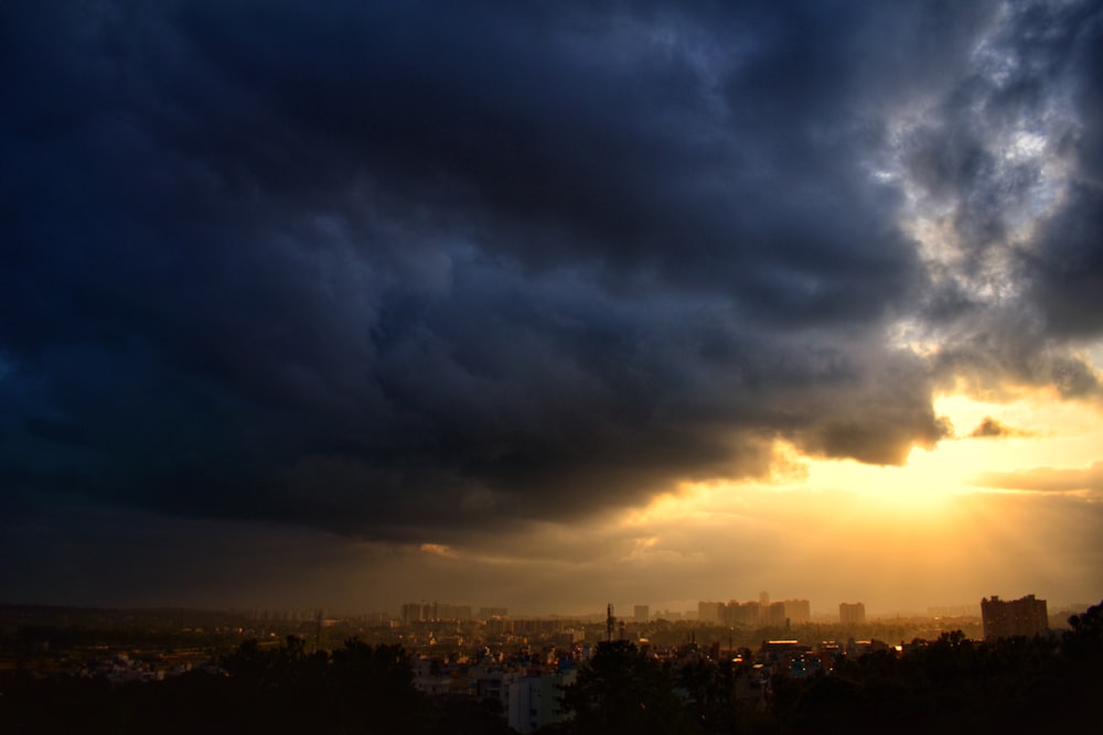 city skyline under gray clouds during sunset