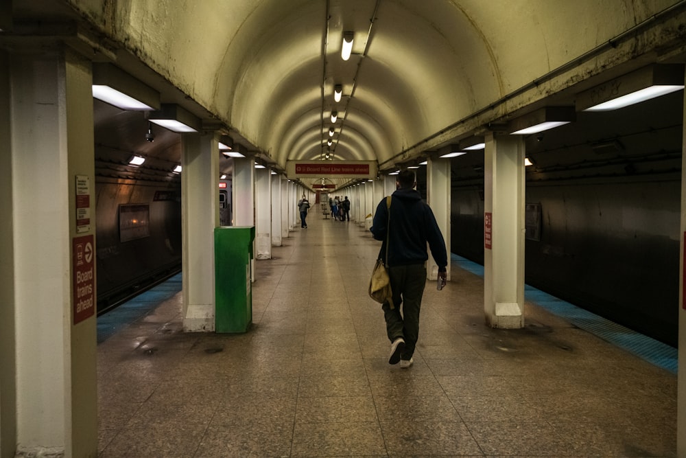 man in black jacket walking on hallway