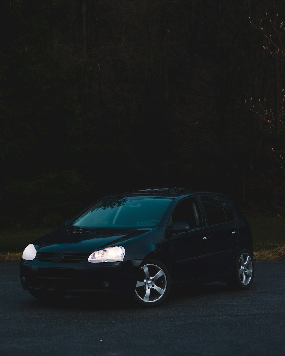 blue volkswagen 5 door hatchback on road