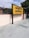 A yellow and black signboard prominently displays the name 'ABUROAD' in both Hindi and English, along with additional text in red below. The sign is positioned on a platform with a tiled floor. Greenery is visible in the background along with a blue sky partially covered by clouds.