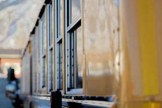 Instructor guiding a trainee through a pre-trip inspection on a bright yellow school bus.