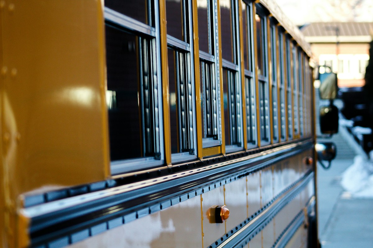 Yellow and white train on tracks during daytime, illustrating transportation options for class trip planning tips.