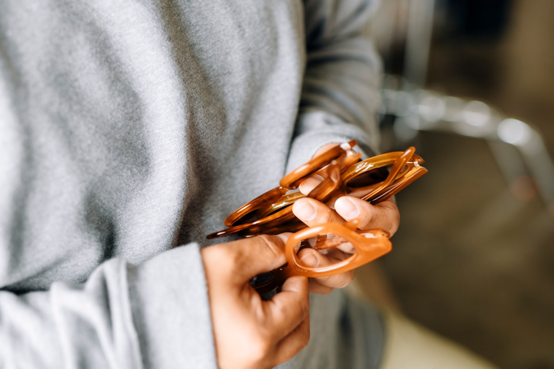 person in gray long sleeve shirt holding brown plastic hair clip