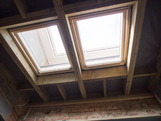 A skilled installer carefully fitting a steel RSJ beam inside a home extension under bright daylight.