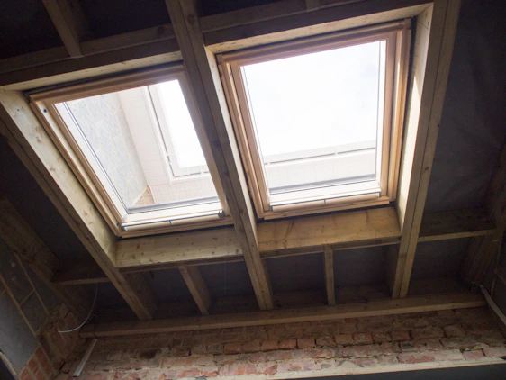 A skilled installer carefully fitting a steel RSJ beam inside a home extension under bright daylight.