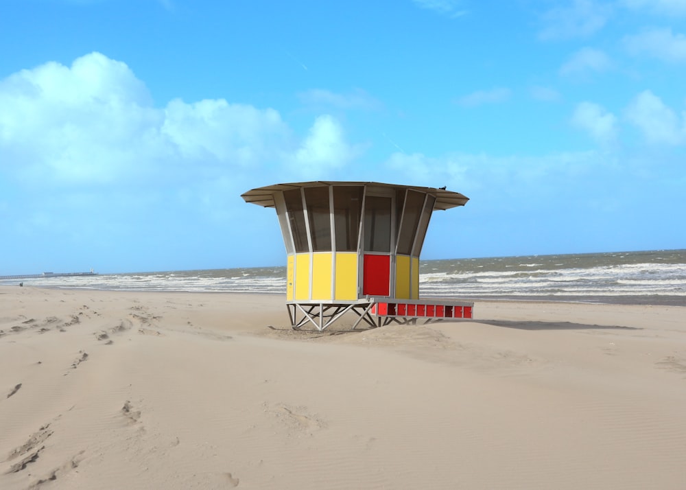 yellow and white lifeguard tower on beach during daytime