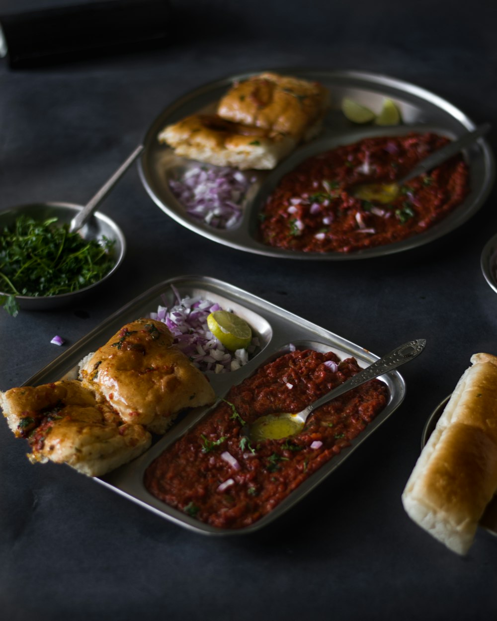 a table topped with three trays of food