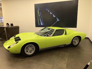 A friendly agent assisting a client with vehicle documents at a bright office desk