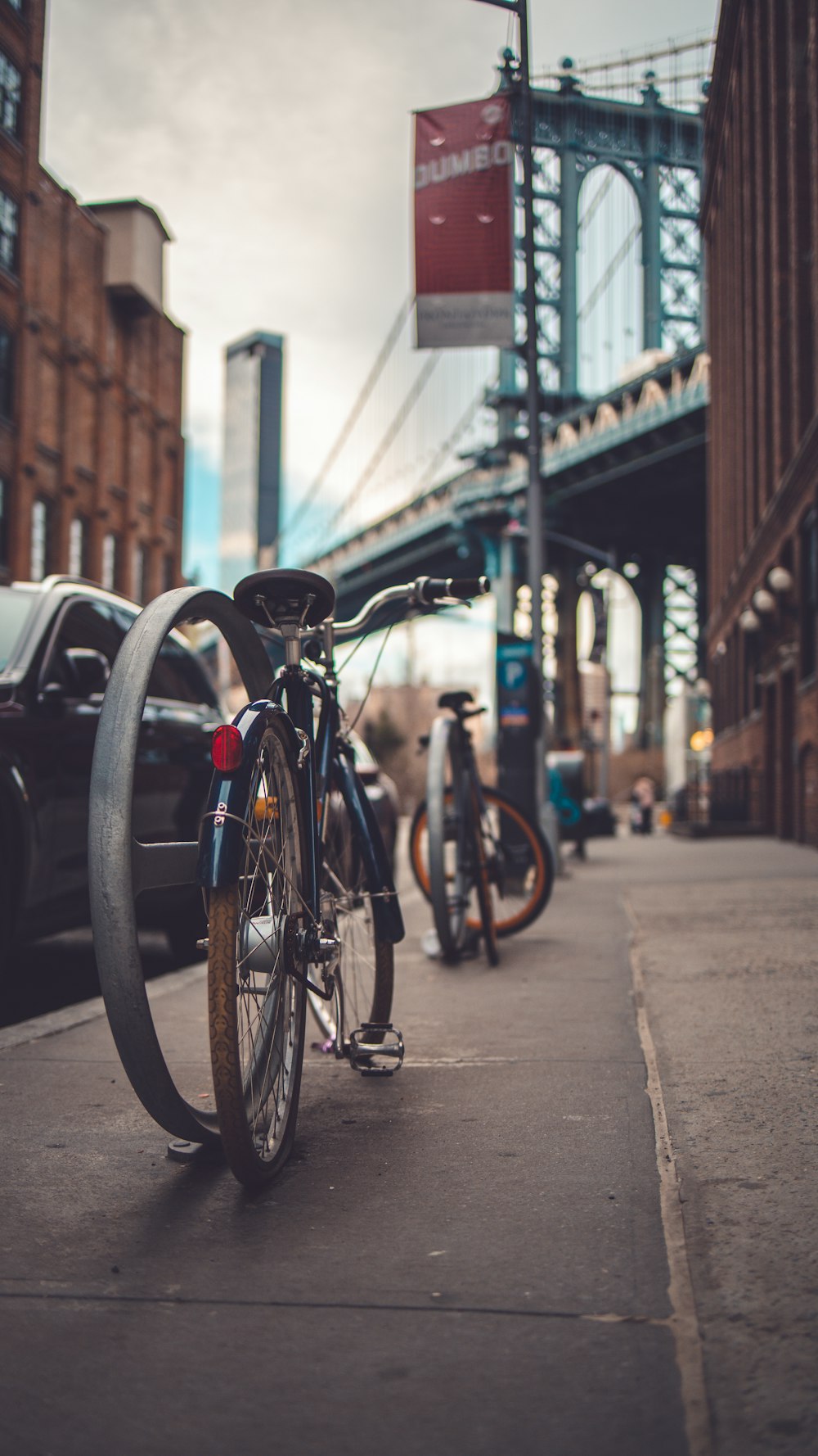 black city bike parked on sidewalk during daytime