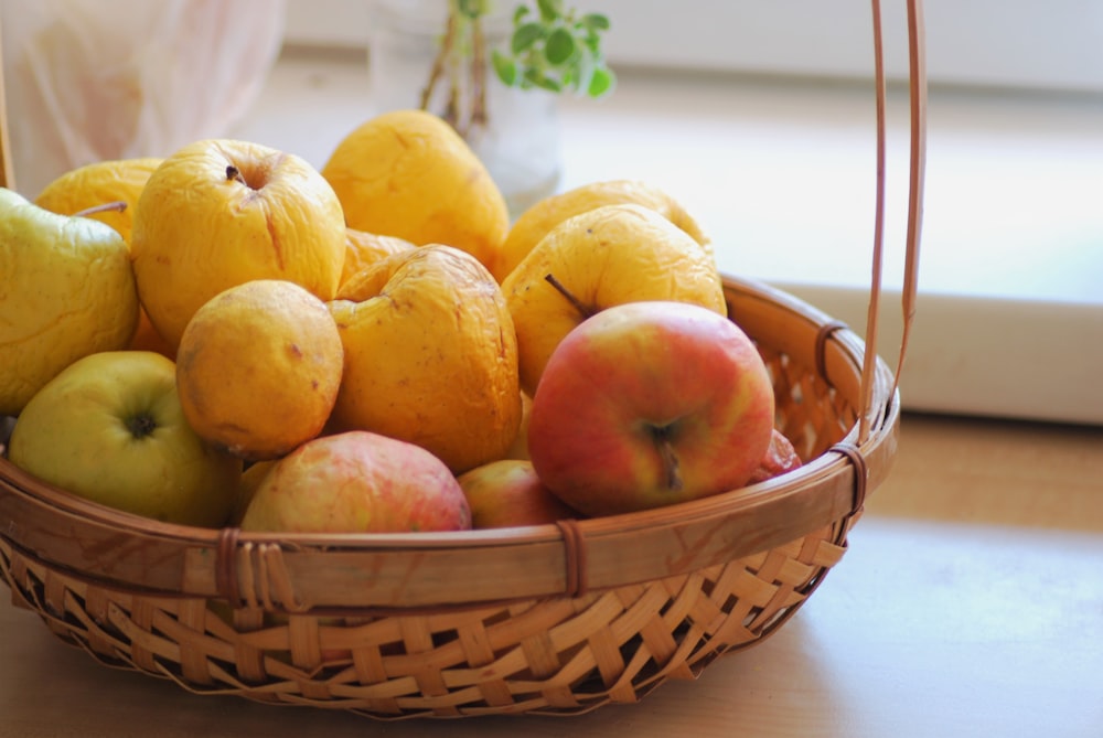 yellow round fruits in brown woven basket