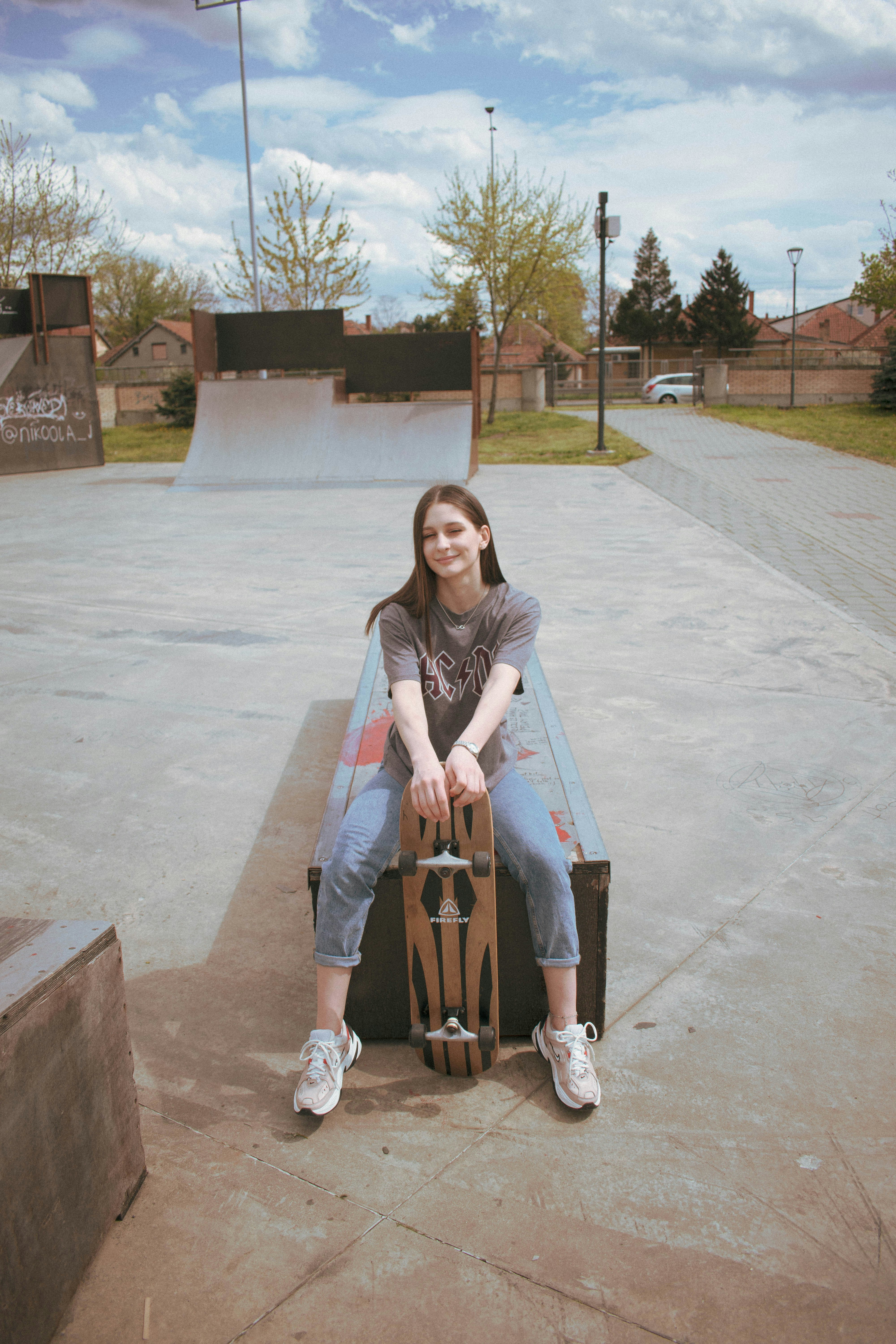 woman in gray jacket sitting on brown wooden bench