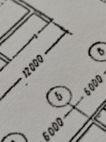 A close-up shot of a woman engineer working on a technical drawing.