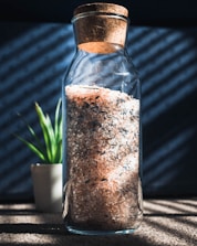 An assortment of artisanal salt blends displayed in elegant glass jars on a kitchen counter.