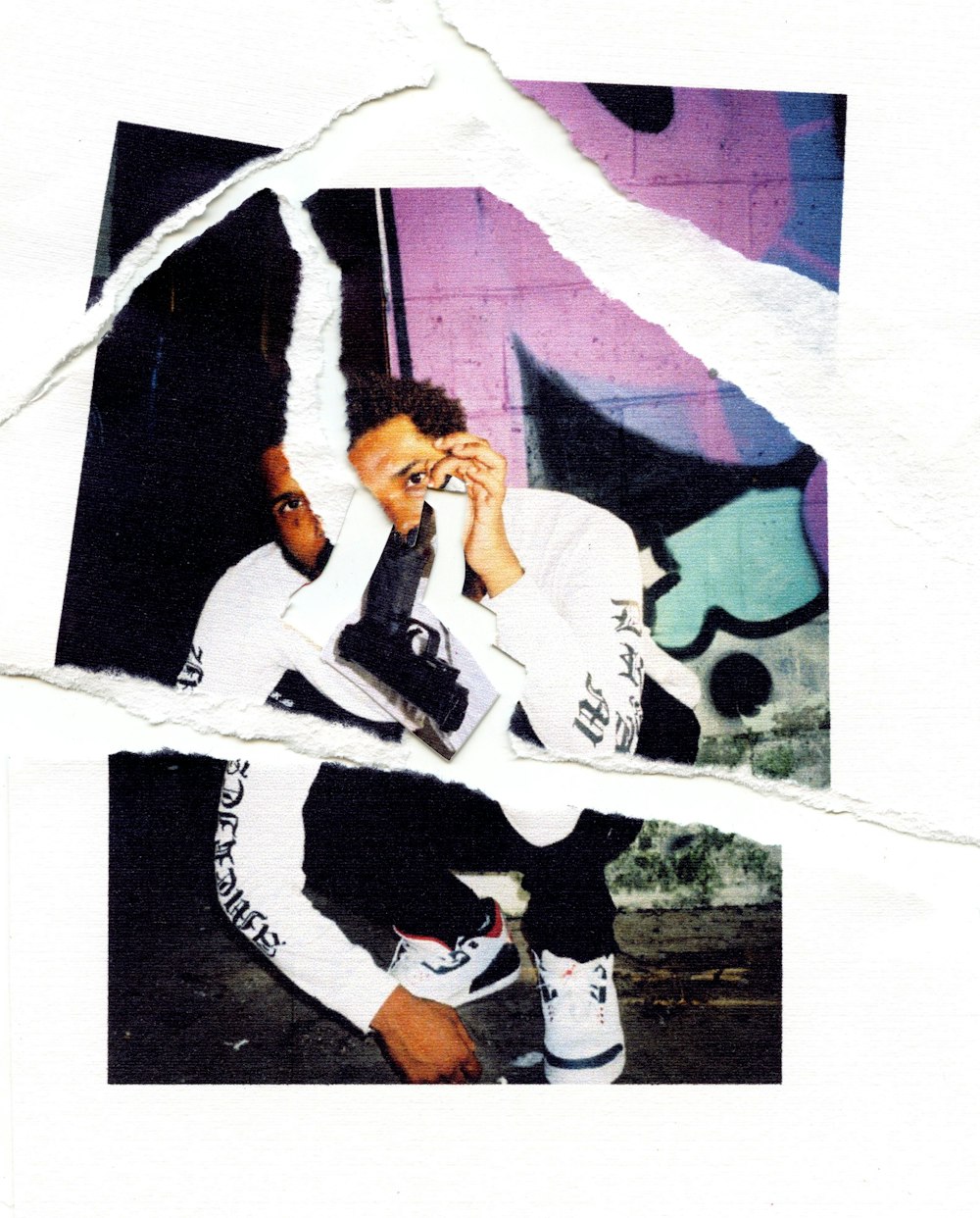 man in black and white long sleeve shirt and black pants sitting on white concrete wall