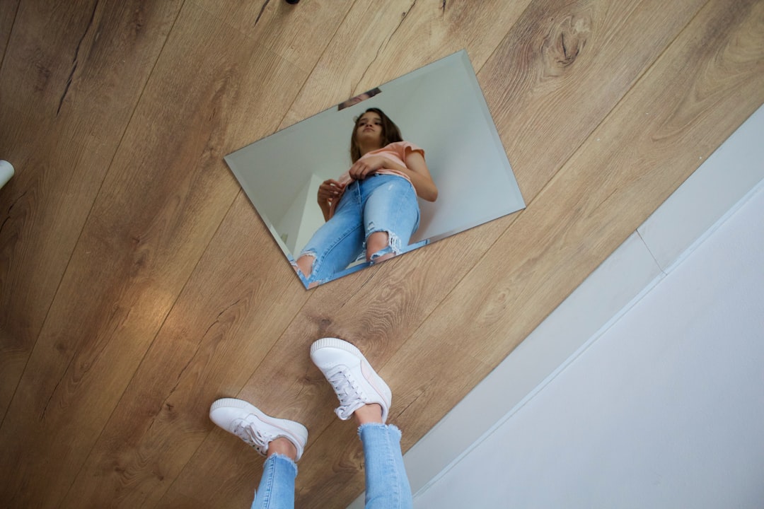 girl in blue shirt lying on white bed