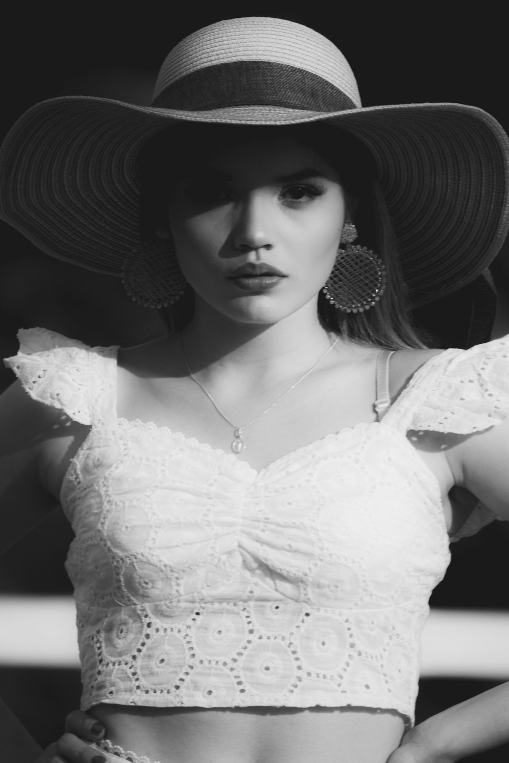 woman in white floral dress wearing sun hat