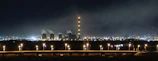 Nighttime view of a large power plant with illuminated electrical infrastructure showcasing high-tech EPC solutions