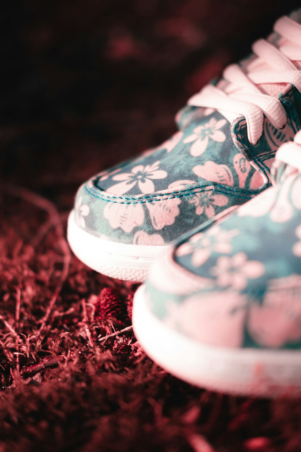 person wearing white and blue floral sneakers