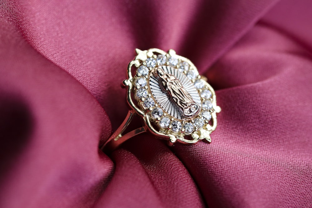 silver diamond studded ring on pink textile