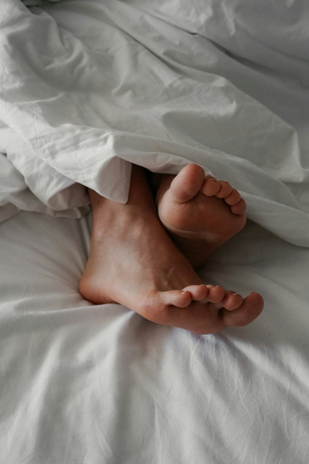 persons feet on white textile