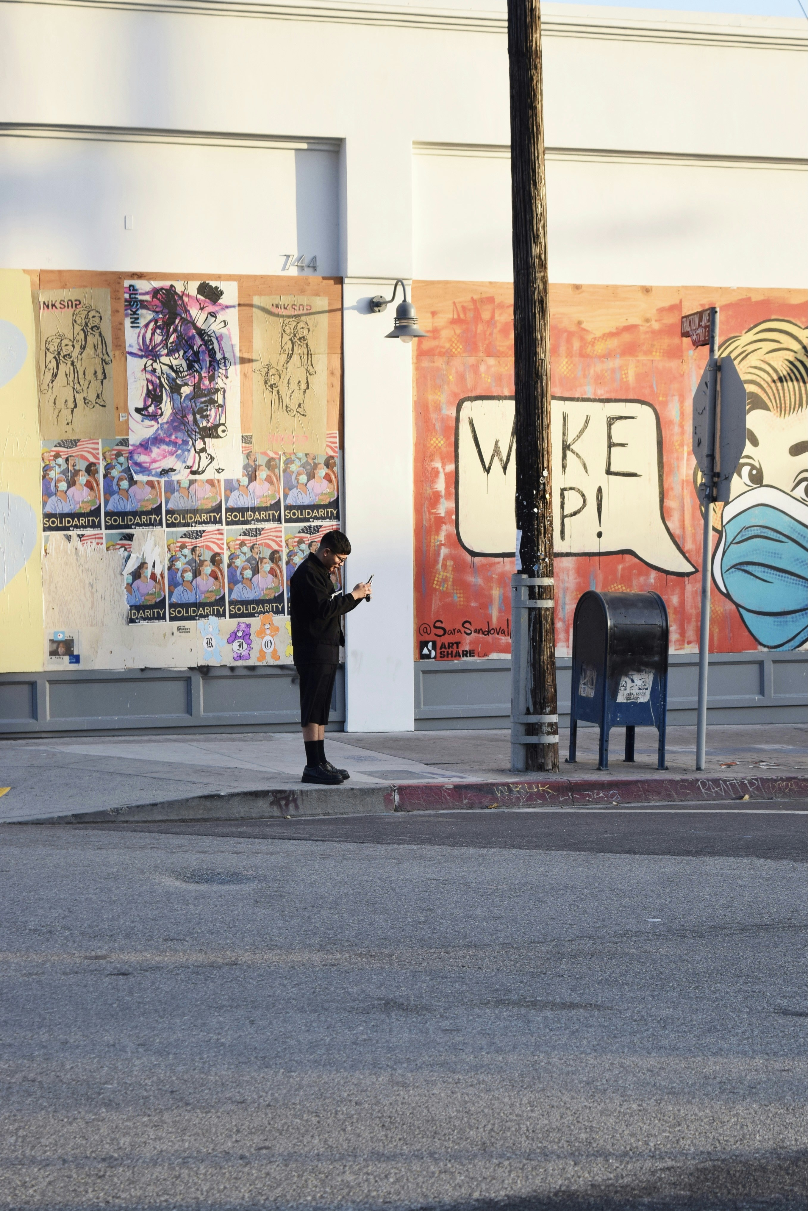 woman in black jacket walking on sidewalk during daytime