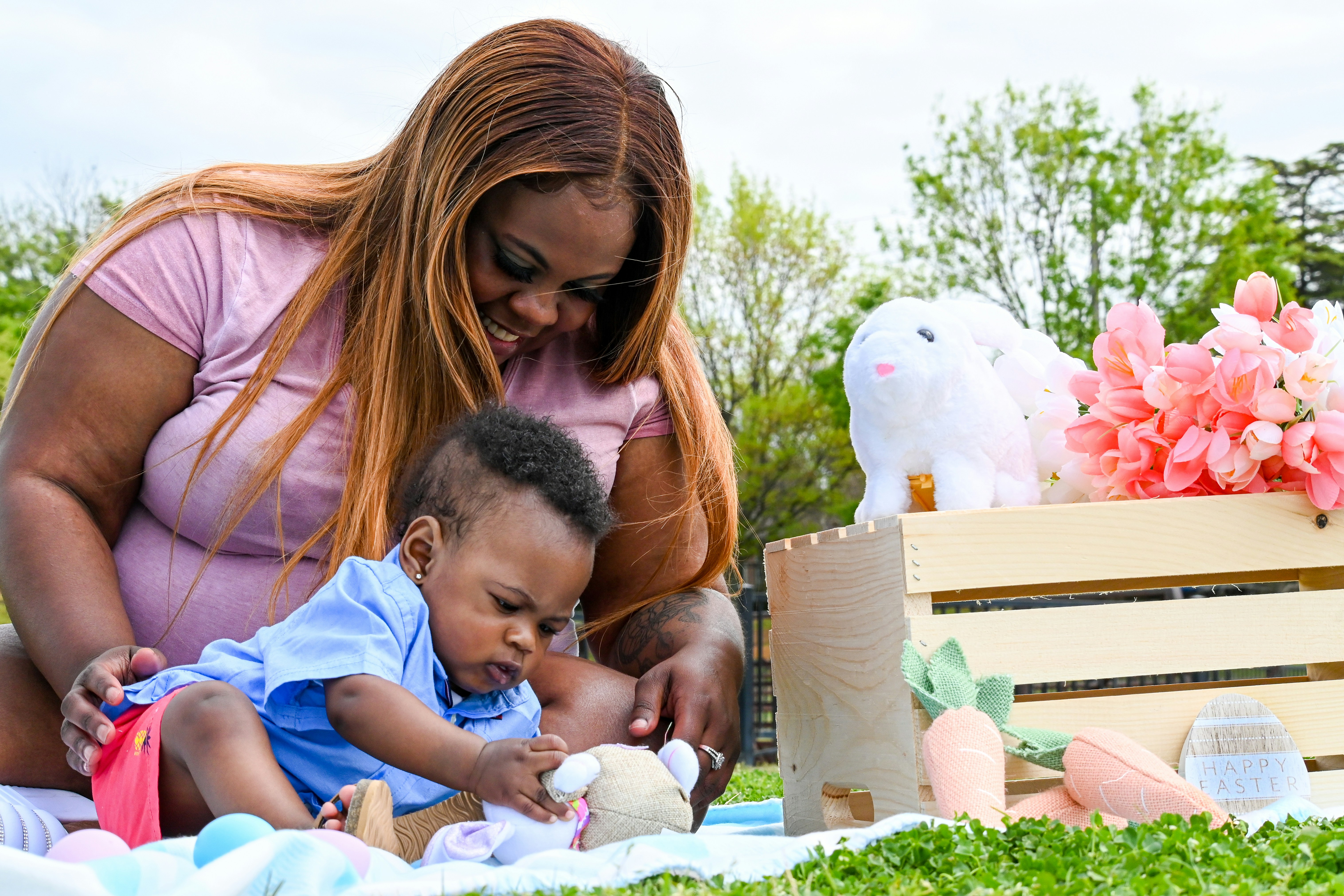 woman in black shirt carrying baby in blue shirt